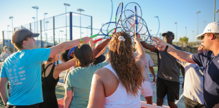 A woman playing tennis at the USTA National Campus.