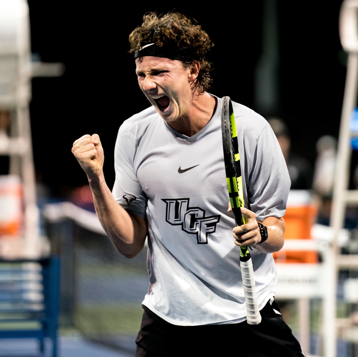 Man in a gray shirt playing tennis